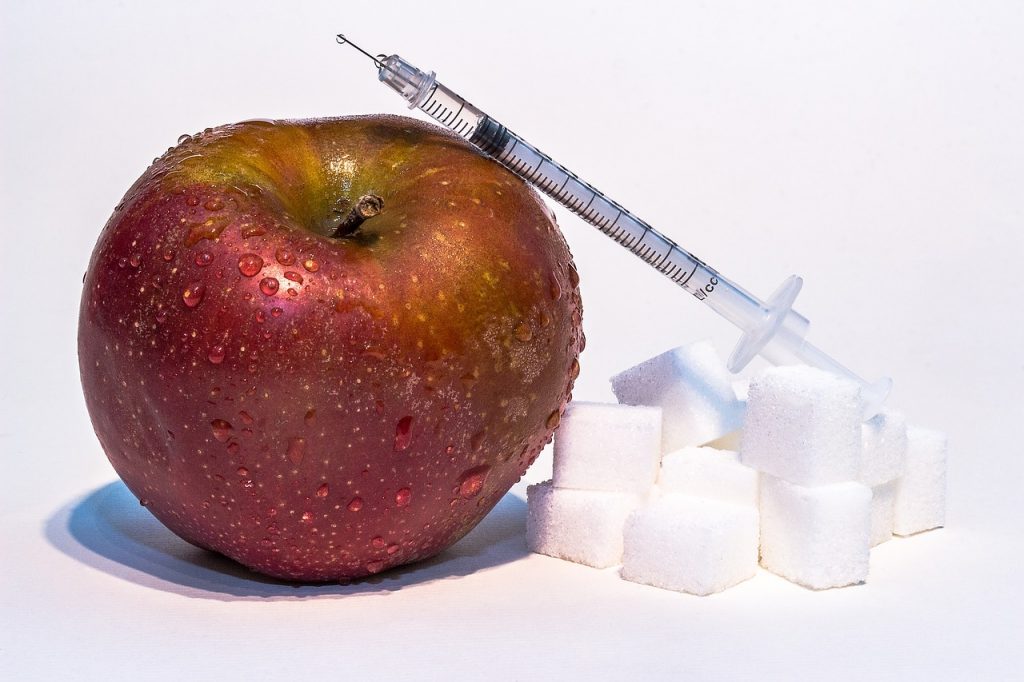 insulin syringe with apple and sugar cubes