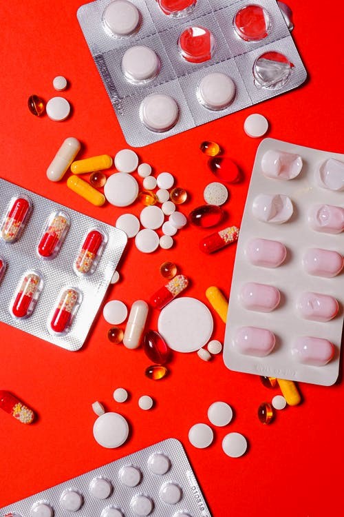 A flat lay of various assorted pills and medications for medical use.