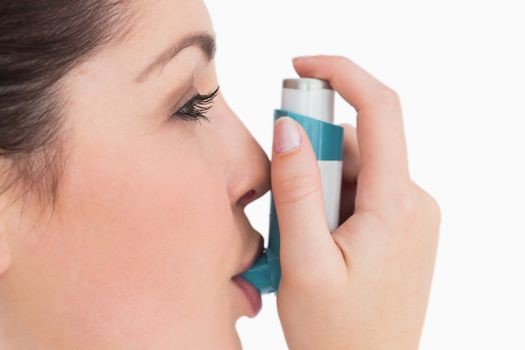 A woman using an inhaler