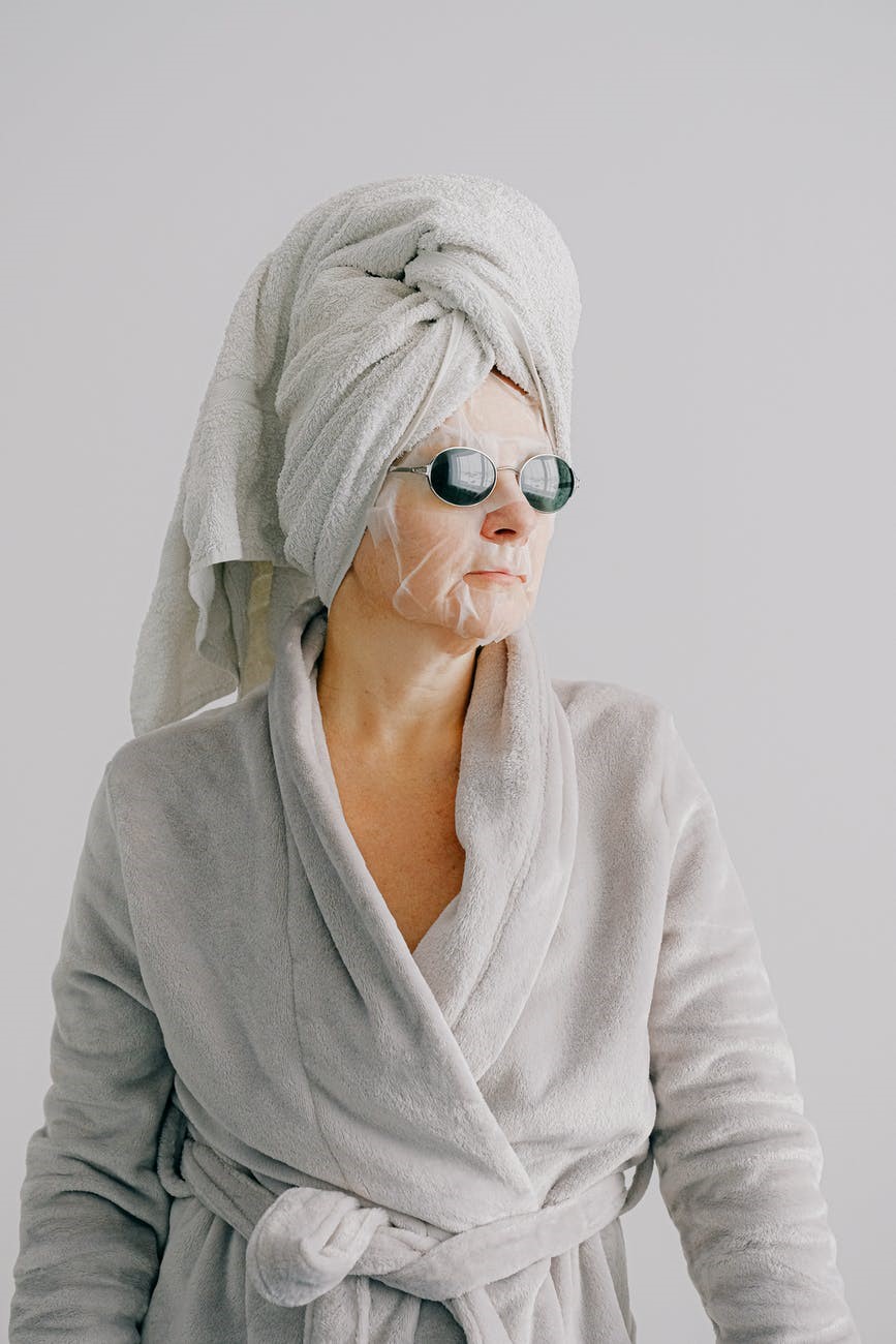 A relaxed woman in bathrobe, towel and face maskA relaxed woman in bathrobe, towel and face mask