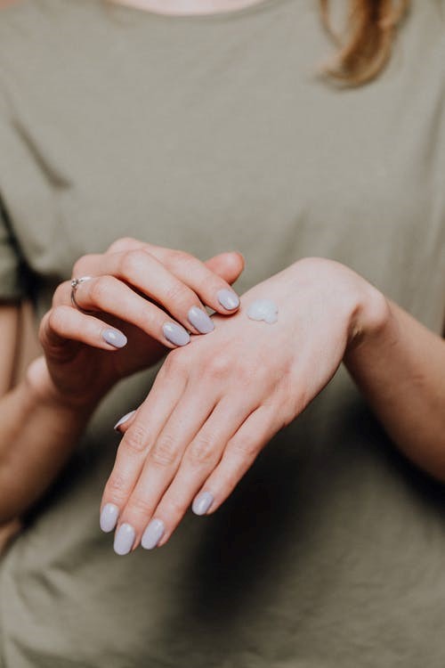A woman applying moisturizer on her hand