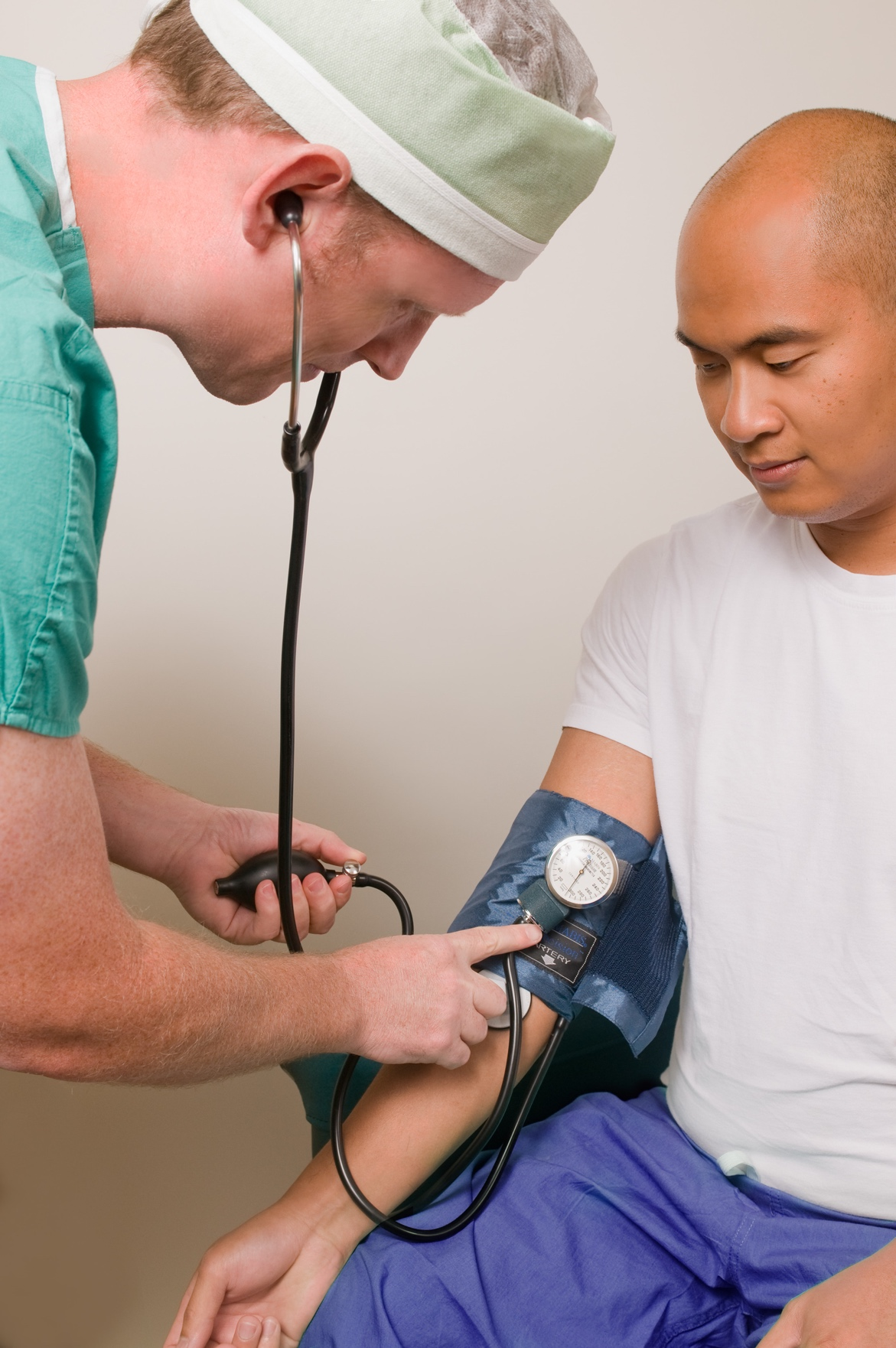 A nurse checking a man’s blood pressure.