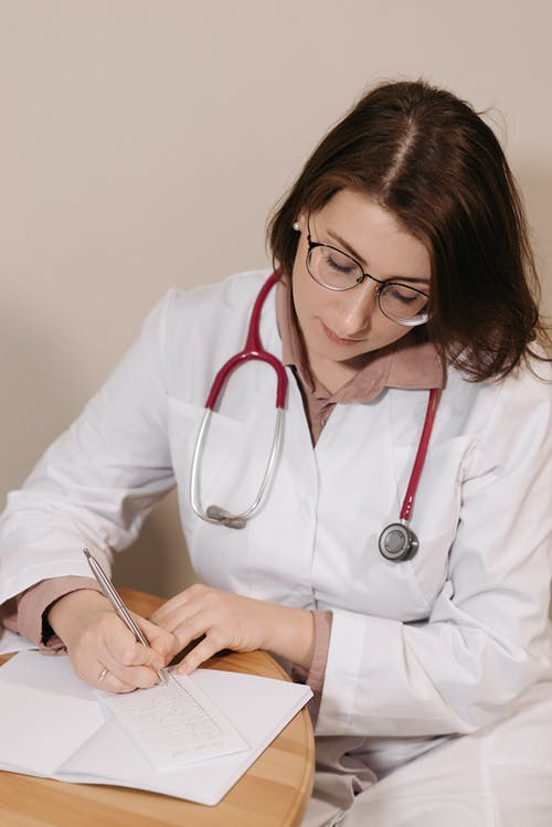 An assistance provider writing a patient's information.