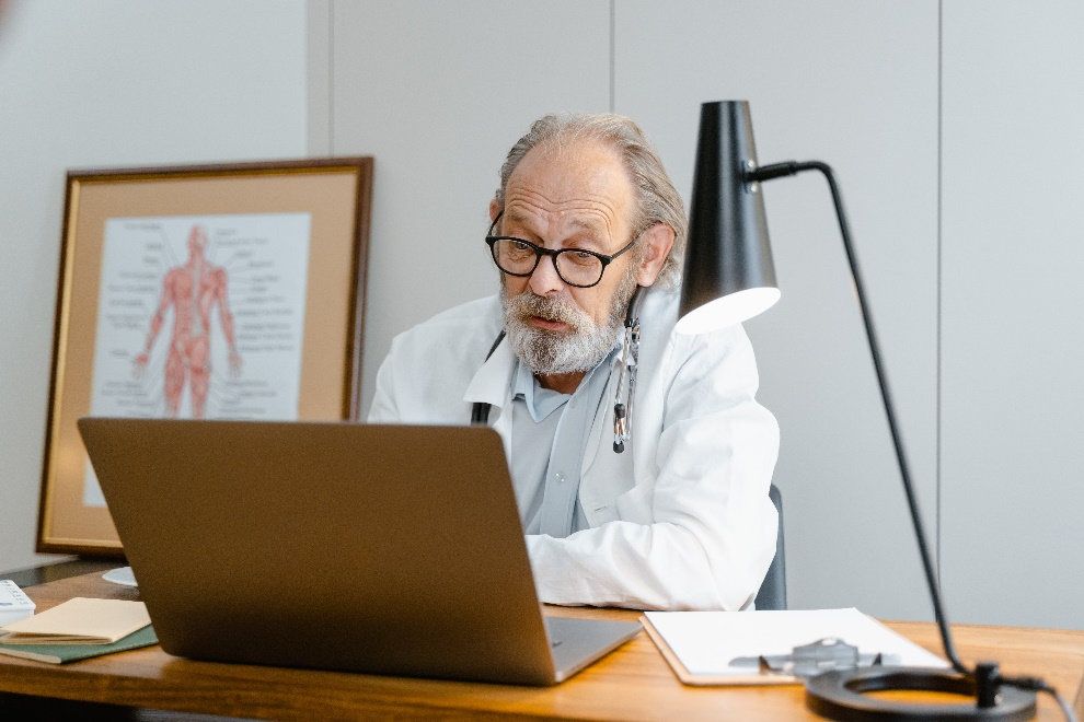 Elderly doctor and laptop