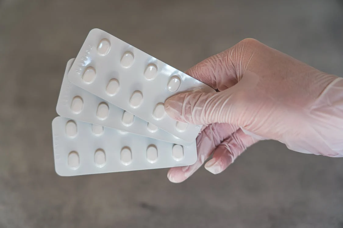 Person holding white blister packs