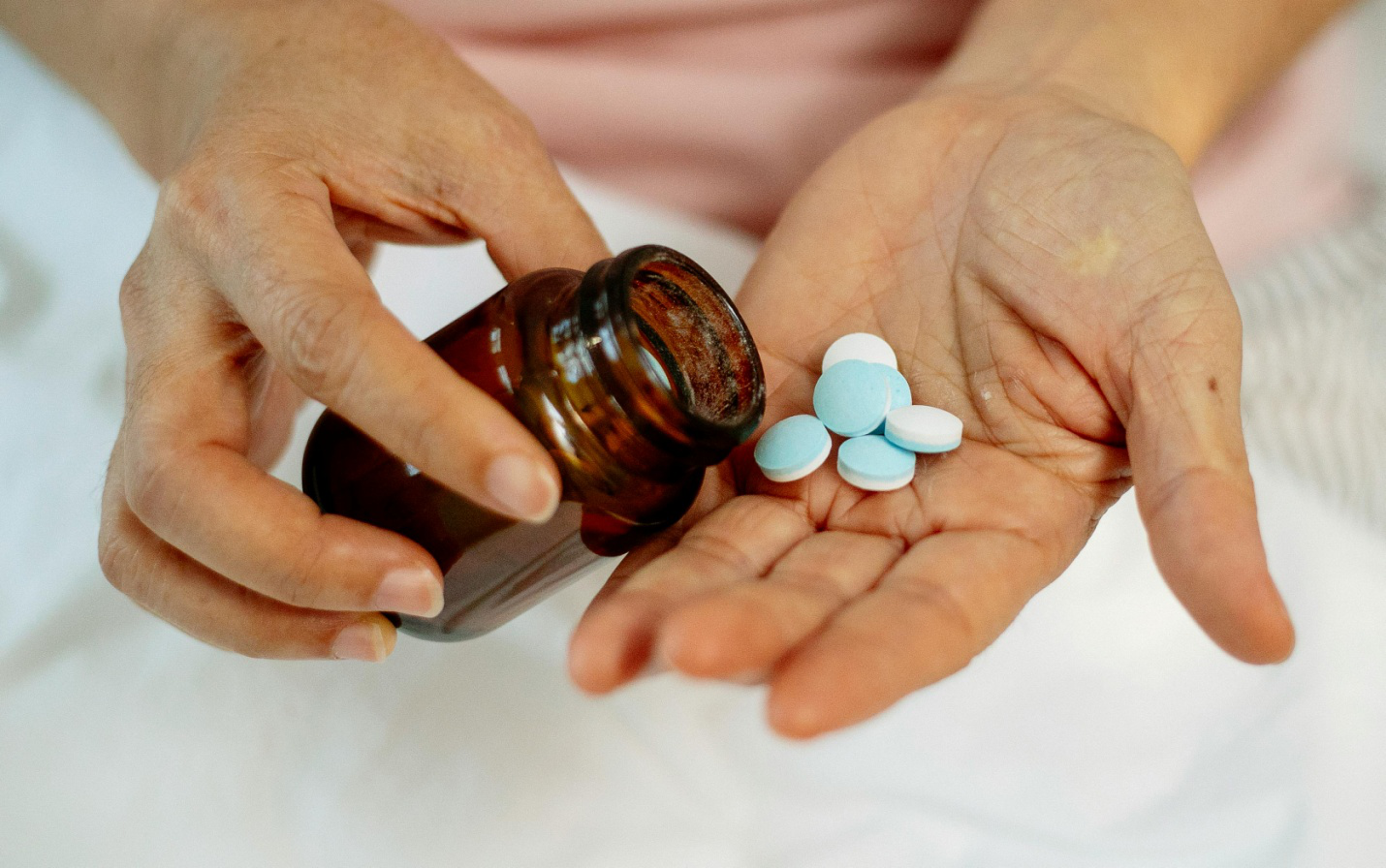 a person pouring medicines into their hand