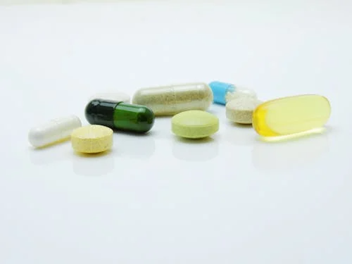 Assorted medical tablets and pills displayed together, symbolizing prescription therapy and medication expenses.