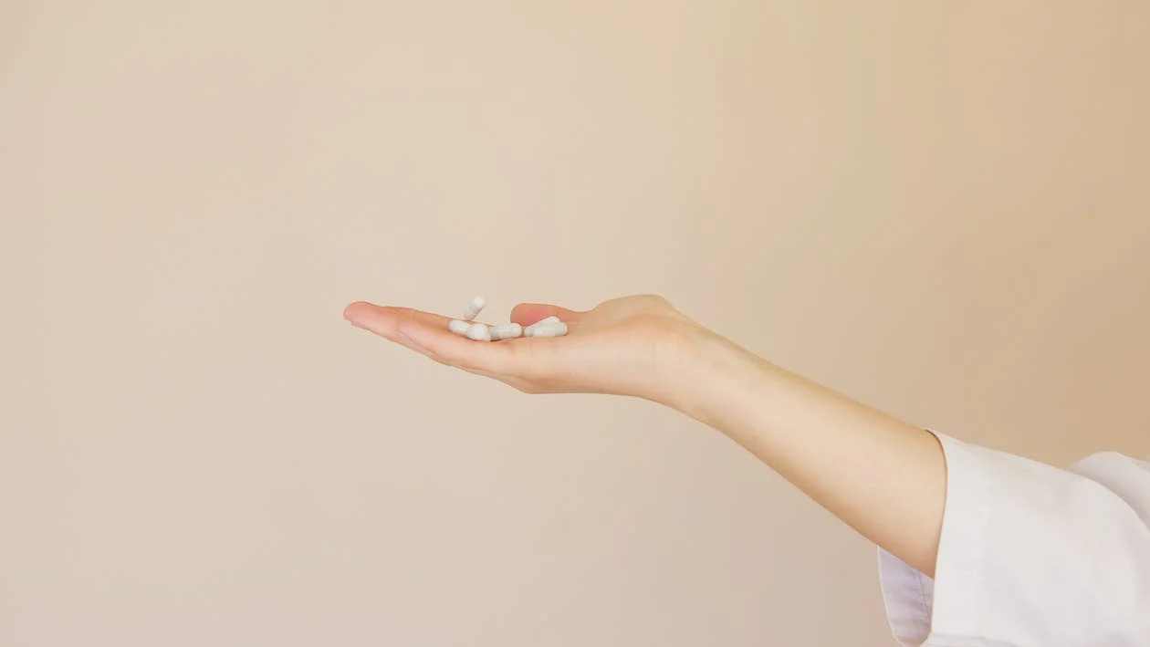 Woman holding a pile of white pills in her palm