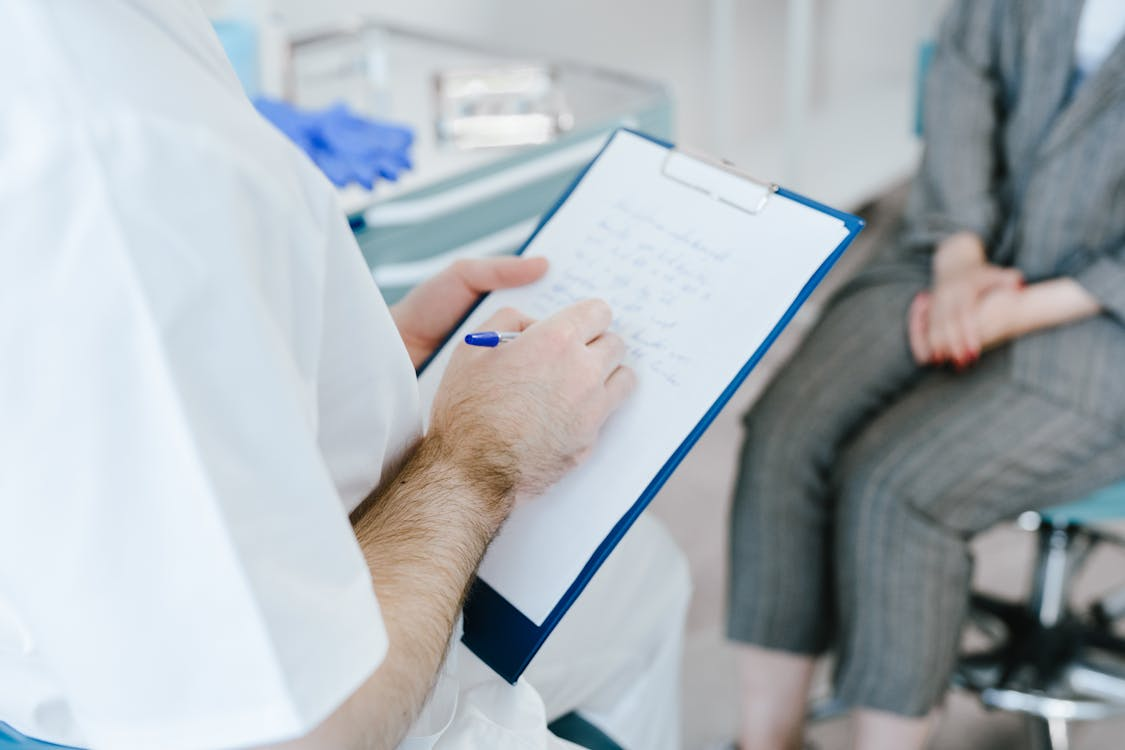 Healthcare provider reviewing documents with an older patient seated nearby.